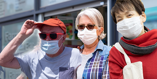 a senior man 2 senior women with masks on in front of a drugstore