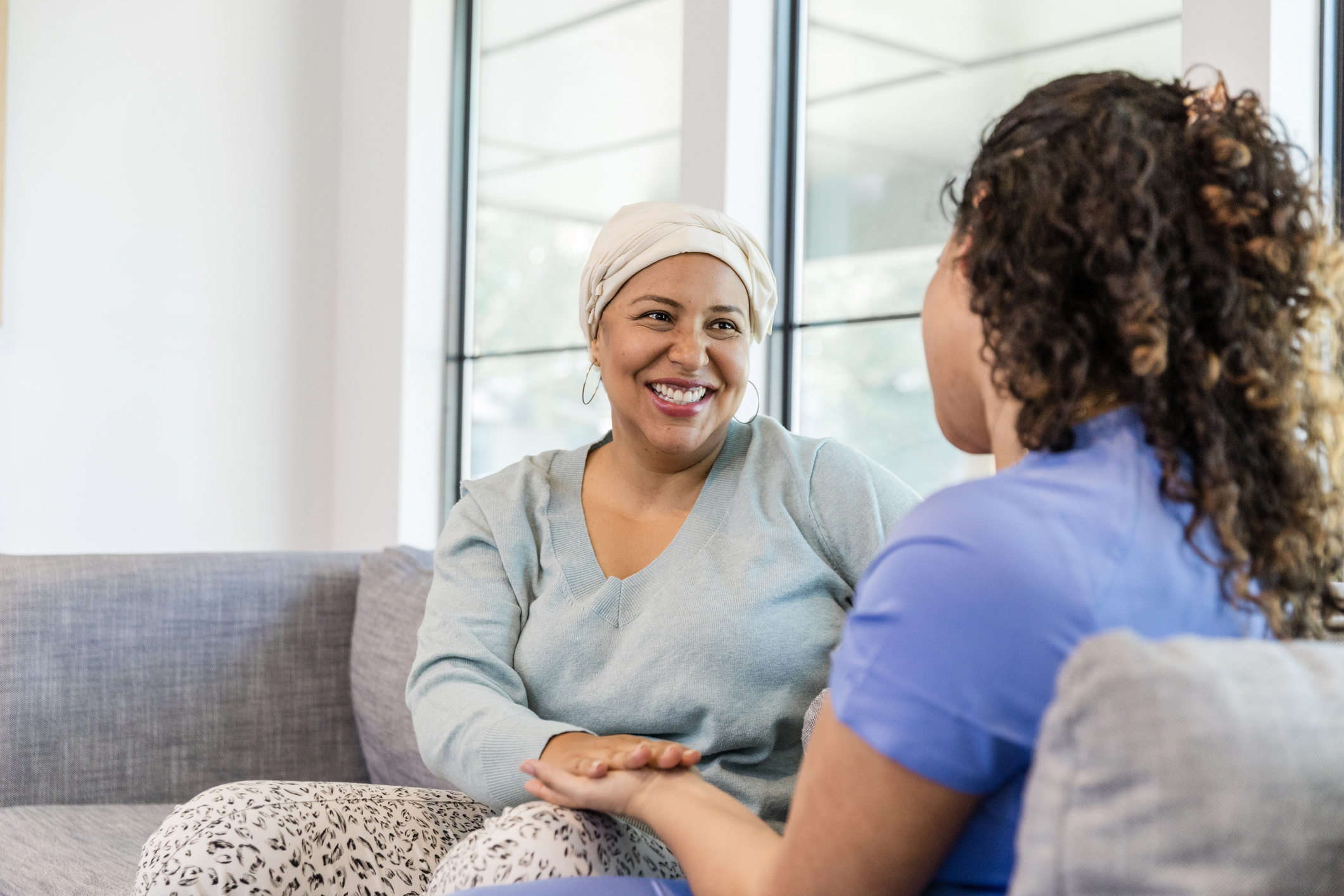 Caregiver offering support to a female cancer patient as they share a moment
