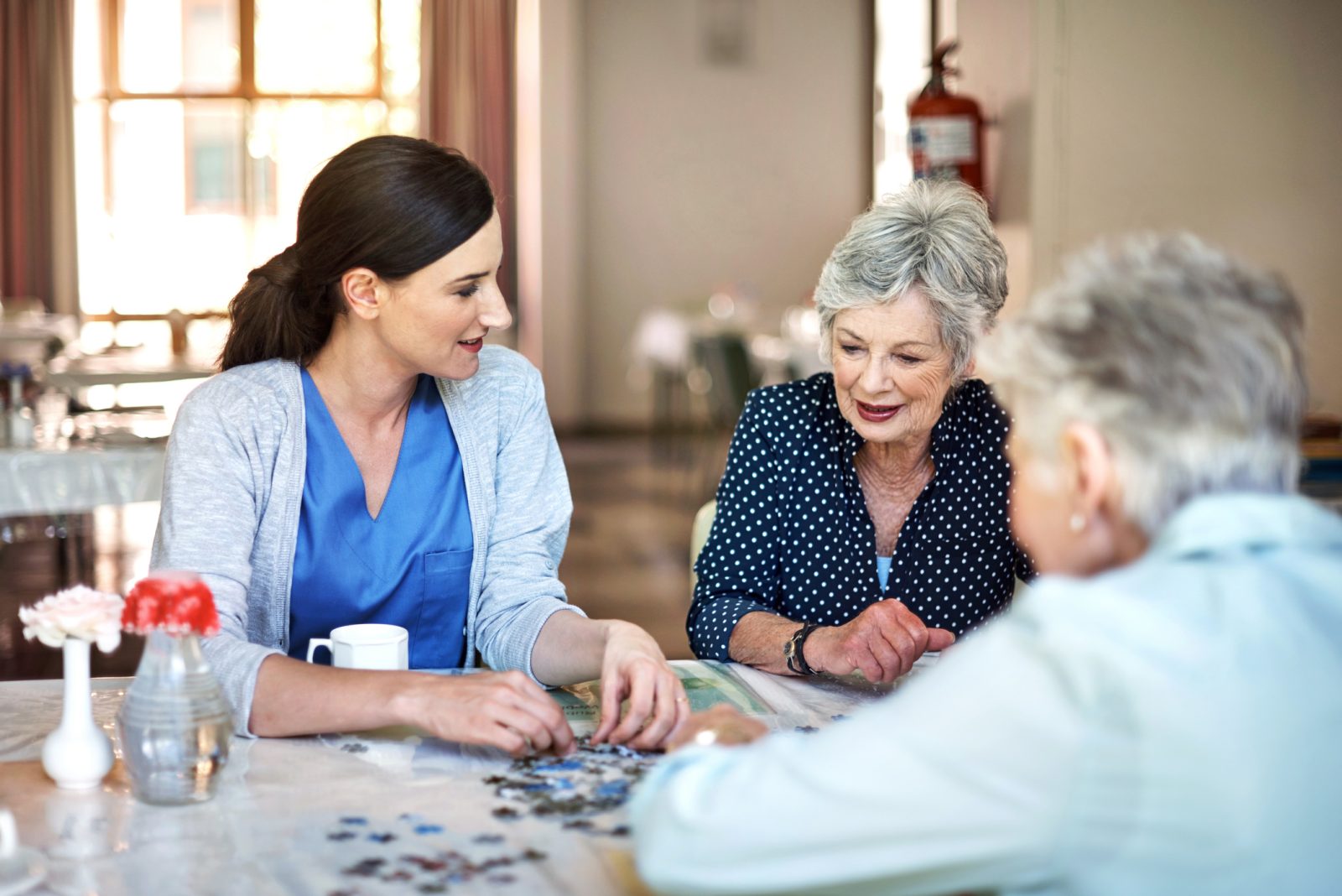 caregiver playing a puzzle with seniors