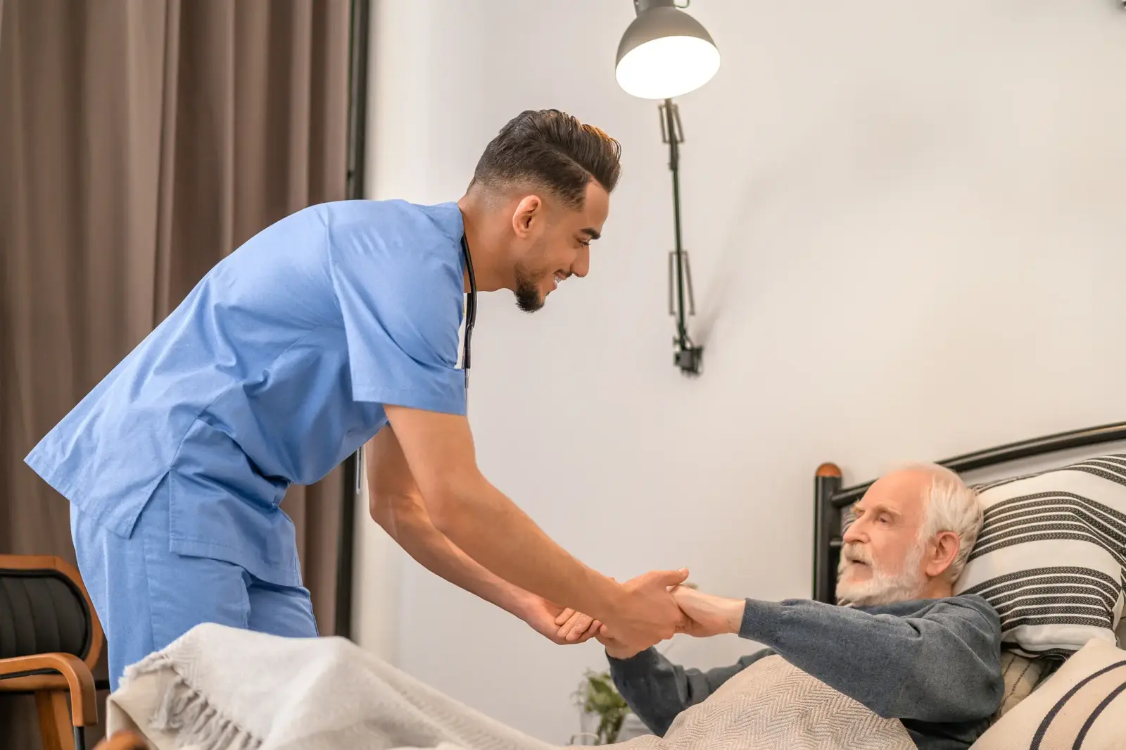 caregiver helping senior out of bed