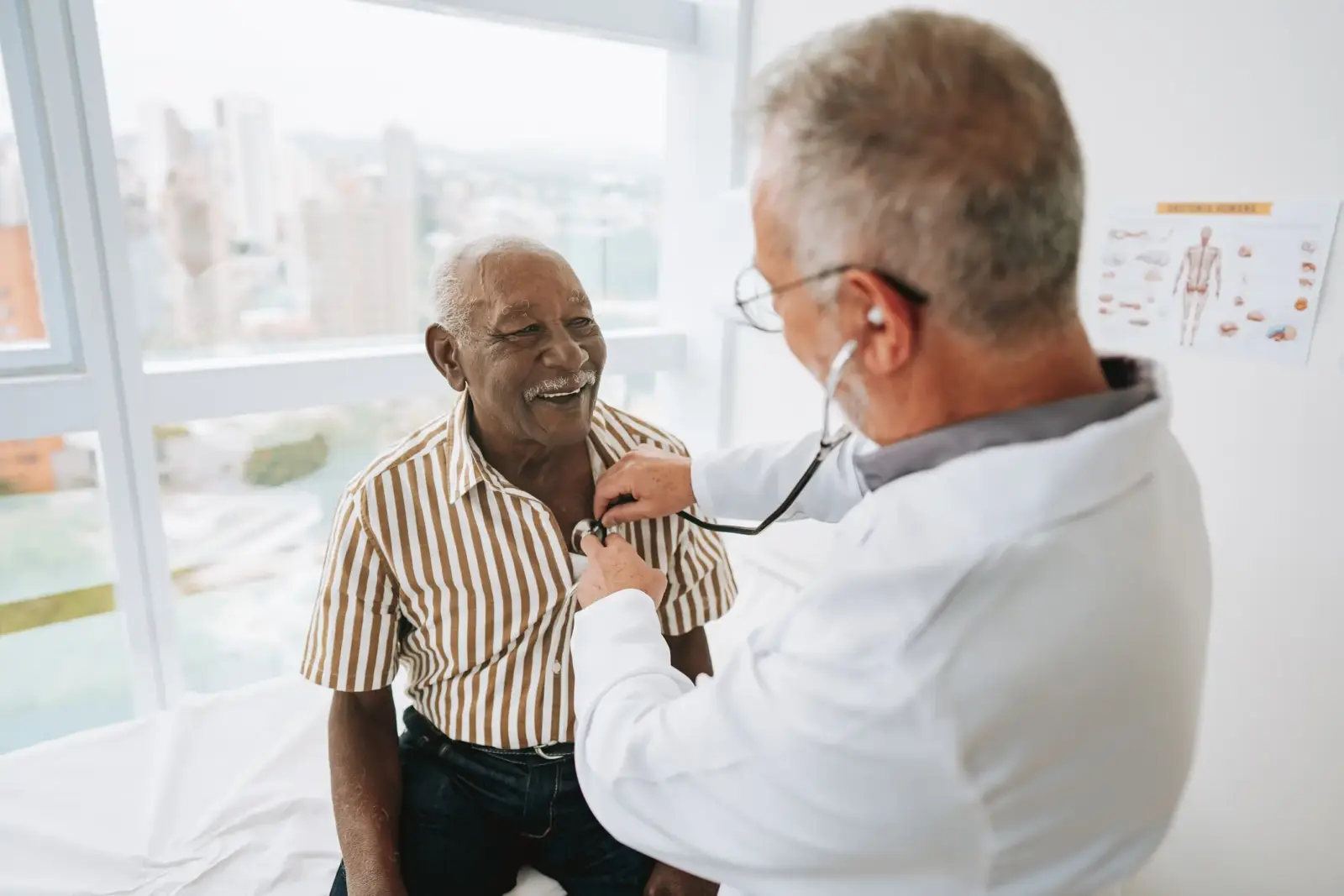 Doctor conducting a heart health checkup on a smiling senior patient