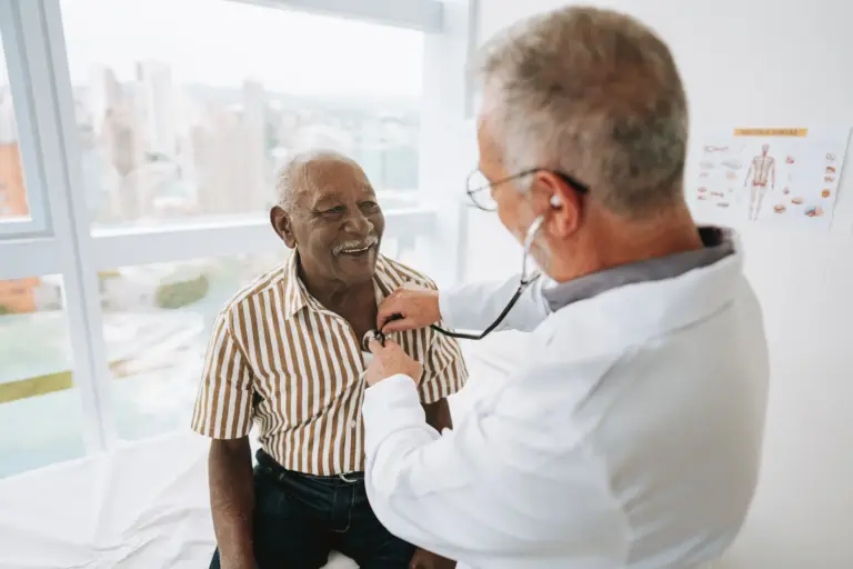 Doctor conducting a heart health checkup on a smiling senior patient