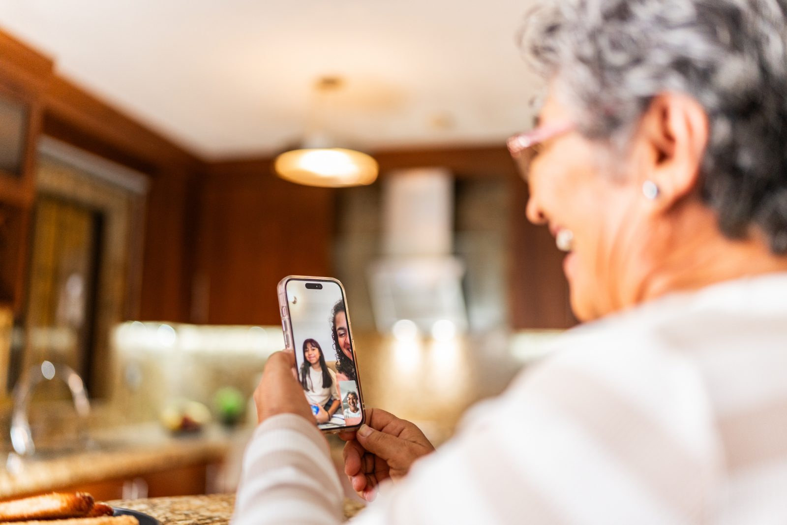 Senior woman video chatting with family from her living room, smiling and relaxed