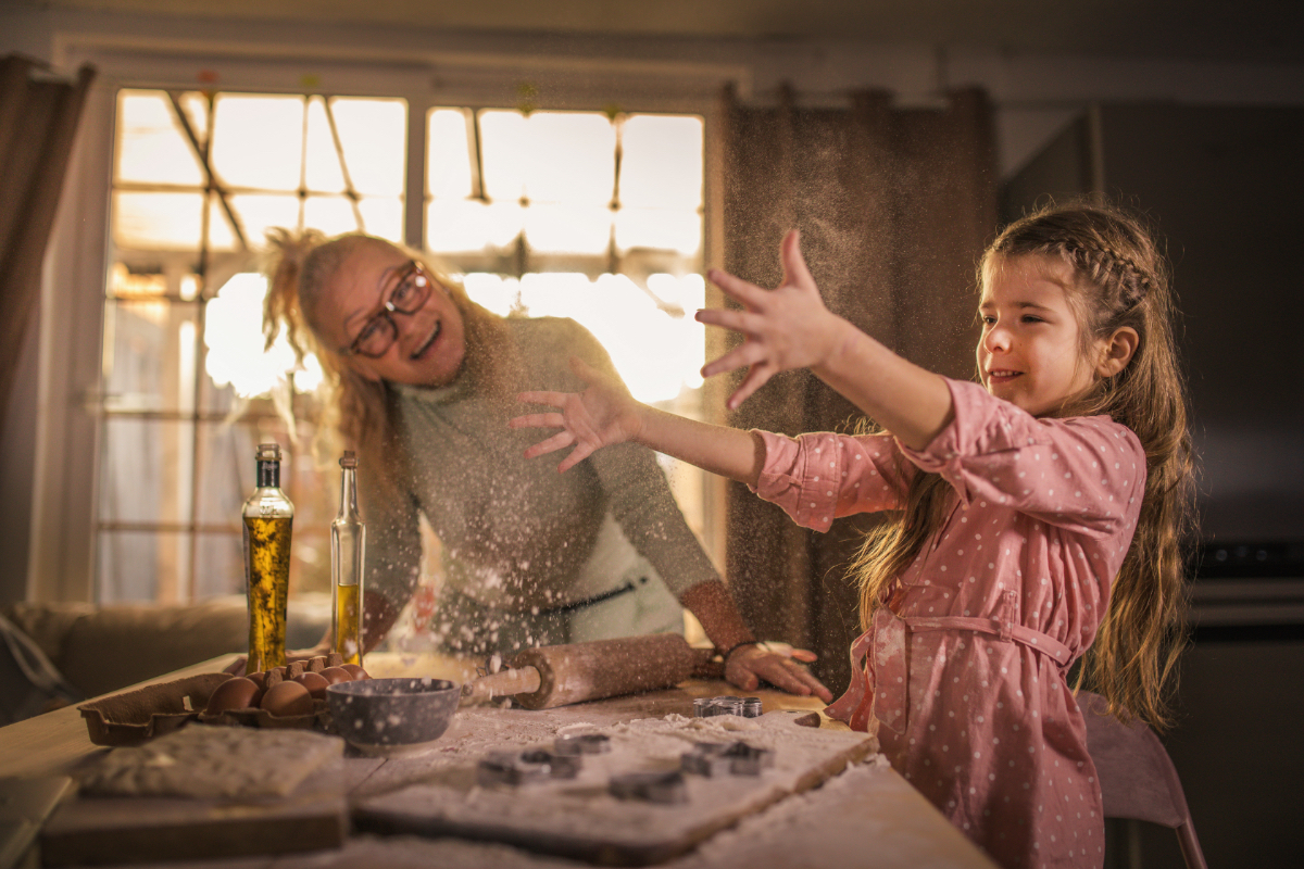 Young girl and her mother bonding while baking cookies.