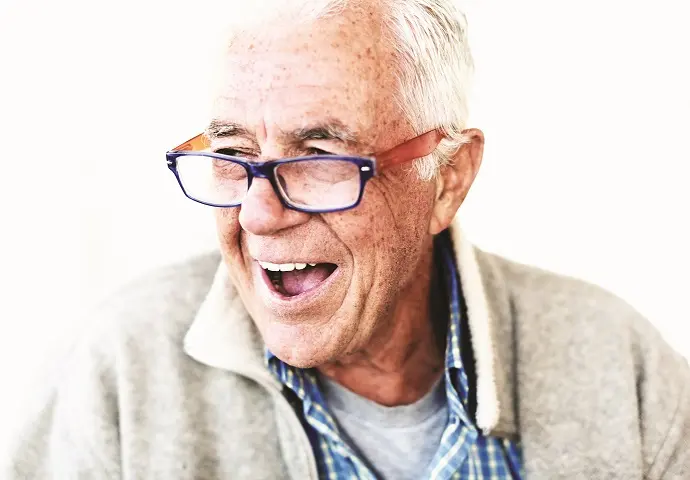 Cheerful and relaxed senior man in eyeglasses smiles