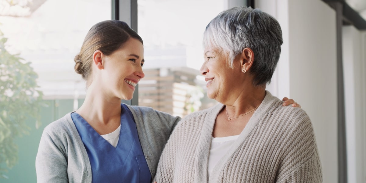 Recovery assistance caregiver helping a senior woman transition from the hospital to home.