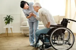 Professional senior caregiver providing safety assistance to elderly client returning home from the hospital
