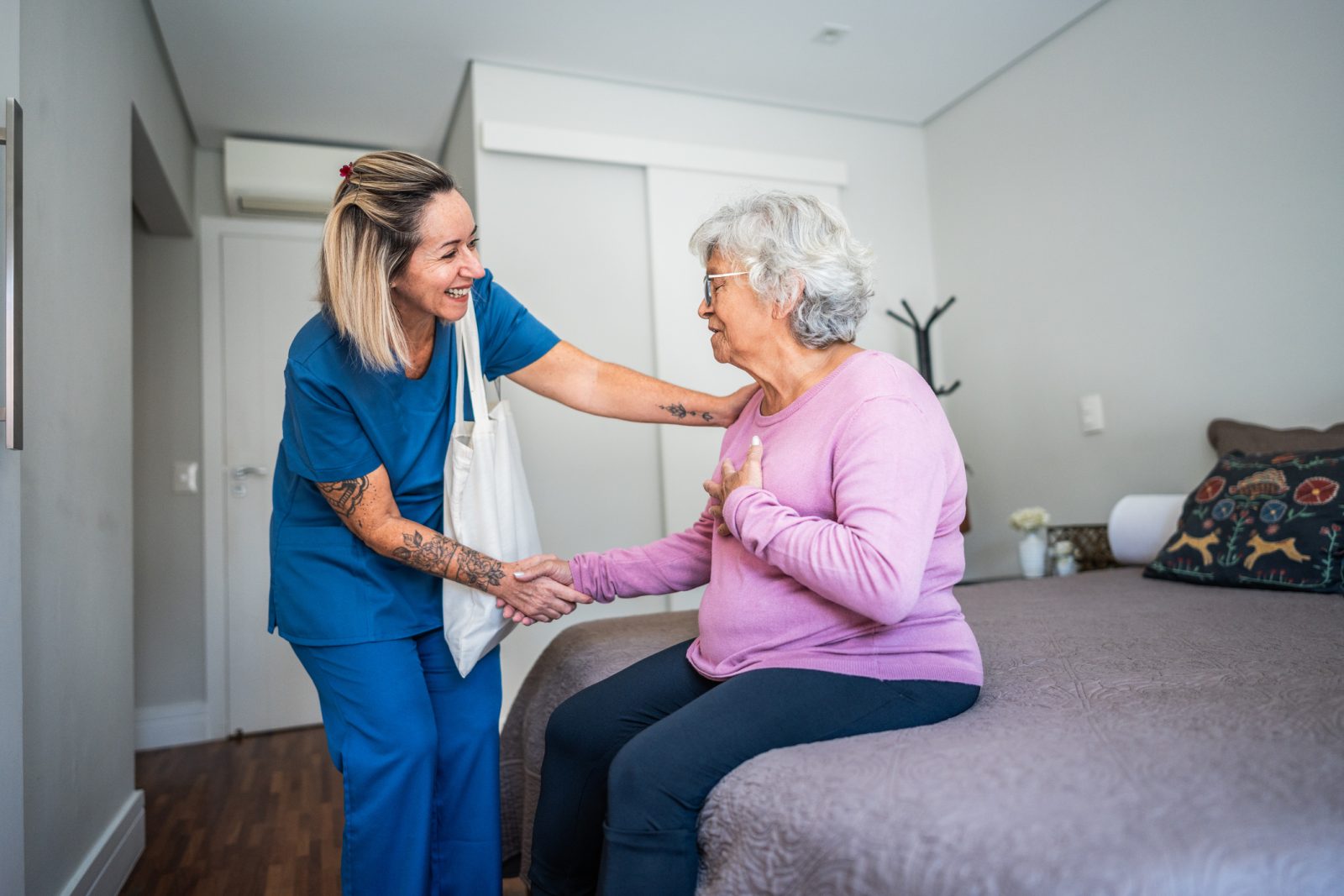 SYNERGY HomeCare senior being helped out of bed.
