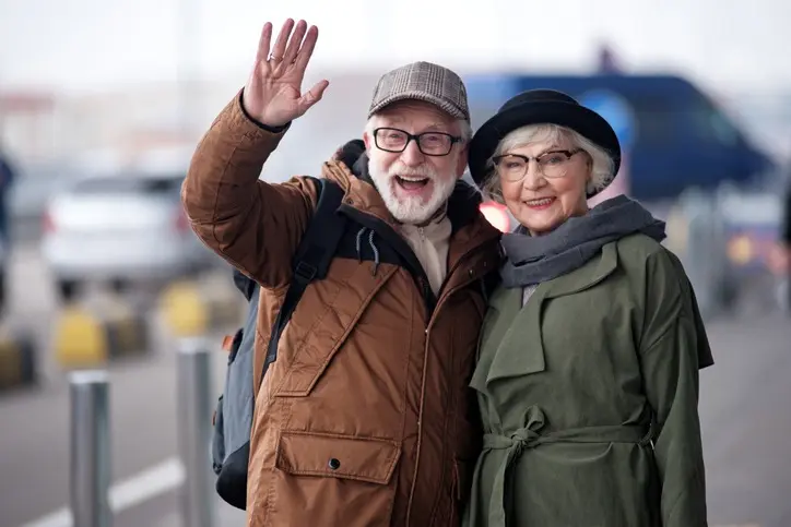 Two senior partners in stylish winter clothing smiling outdoors on a crisp day
