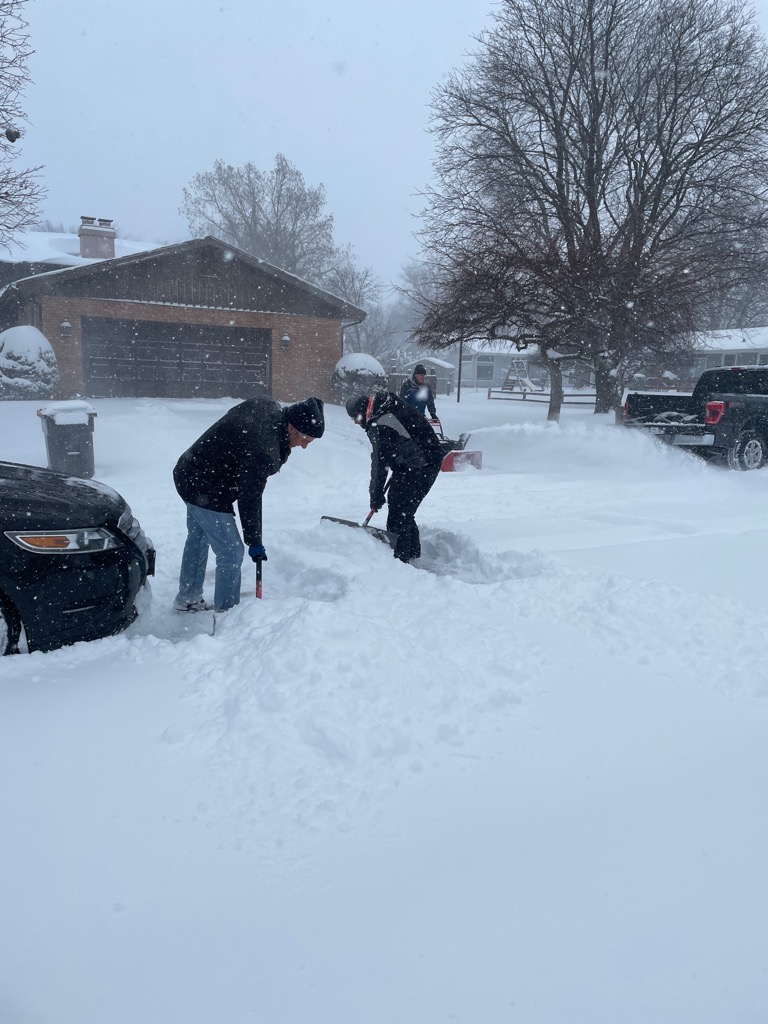 Jim and community member shoveling out a caregivers car.