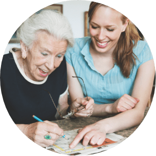 woman and senior woman doing a crossword puzzle